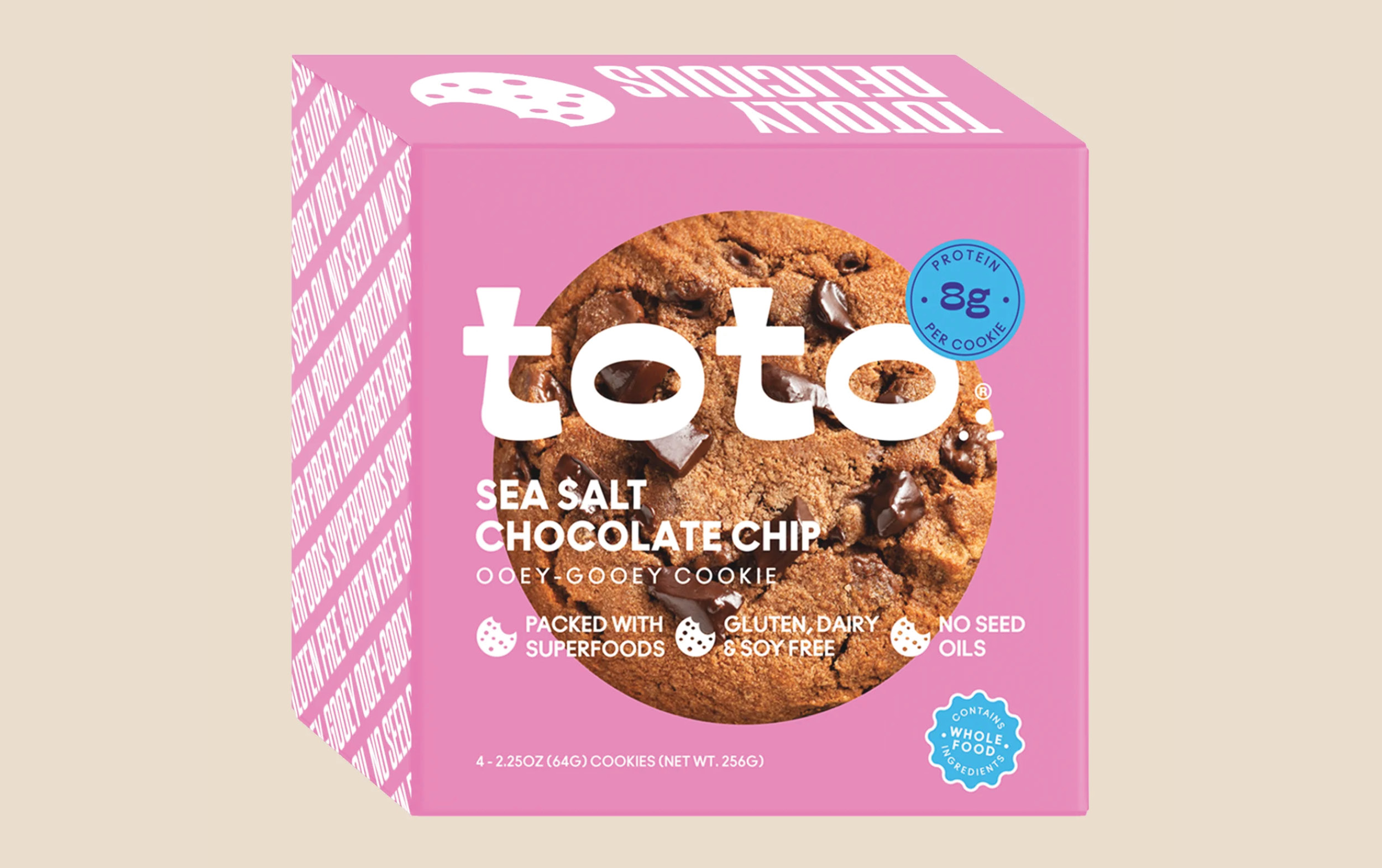 A pink box of toto sea salt chocolate chip cookies, labeled gluten, dairy, and soy free, contains superfoods and no seed oils. The front shows a large cookie and protein content per cookie.