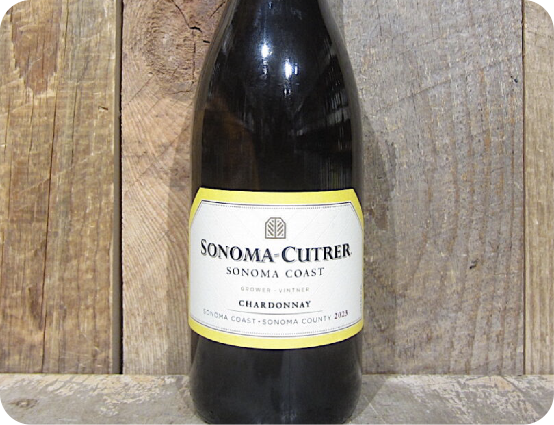 A bottle of Sonoma-Cutrer Sonoma Coast Chardonnay 2023 sits on a rustic wooden surface, its white label gleaming—an ideal choice to elevate any seafood event with crisp, elegant flavors.
