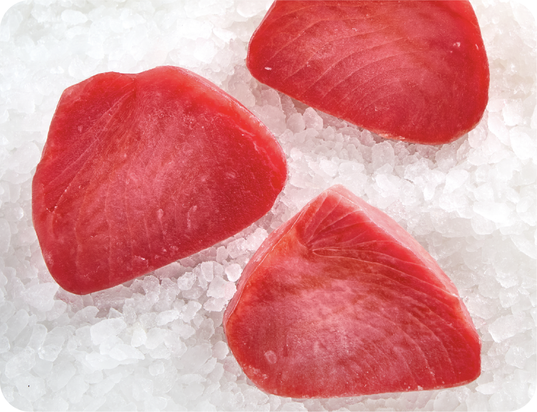 Three pieces of raw, red tuna sashimi are artfully arranged on a bed of crushed ice, creating an elegant seafood display when viewed from above.