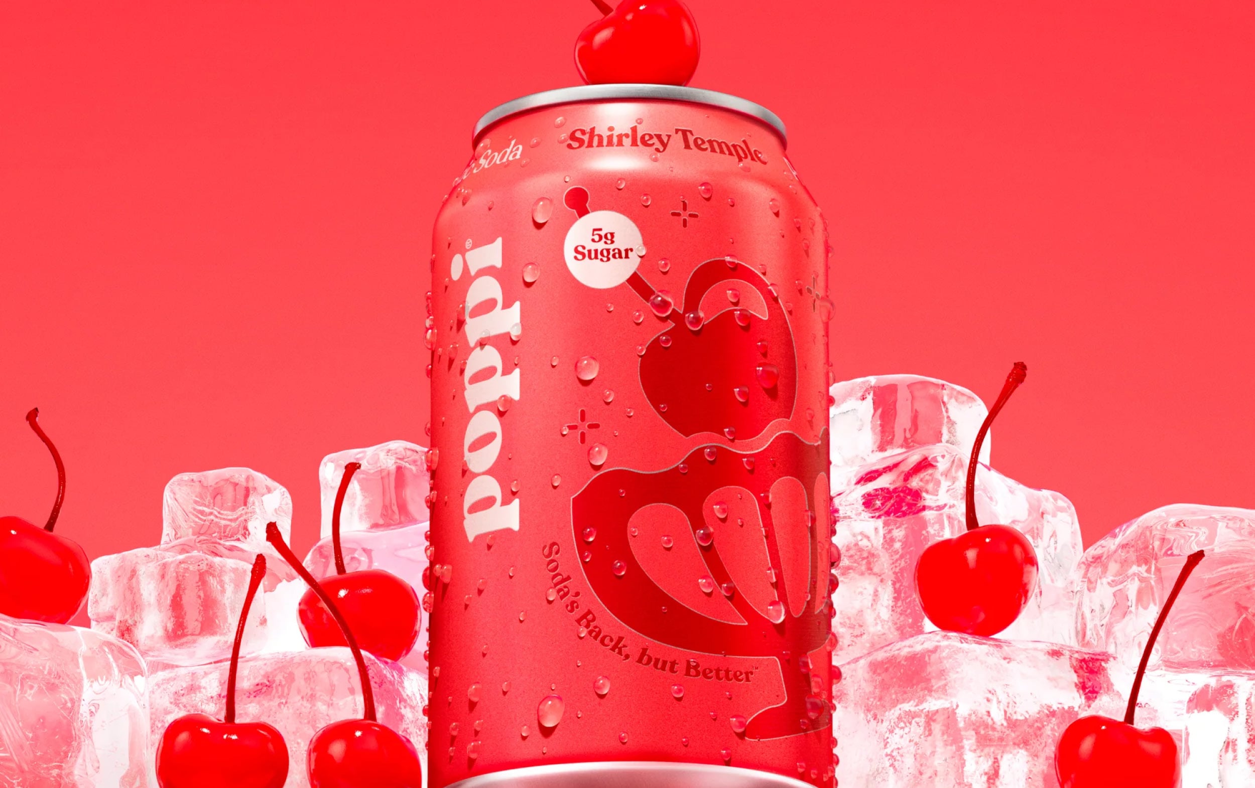 A Poppi Shirley Temple soda can, pink with a cherry graphic, stands among ice cubes and cherries against a vibrant red background. The can displays 5g sugar and the tagline Soda’s Back, but Better.