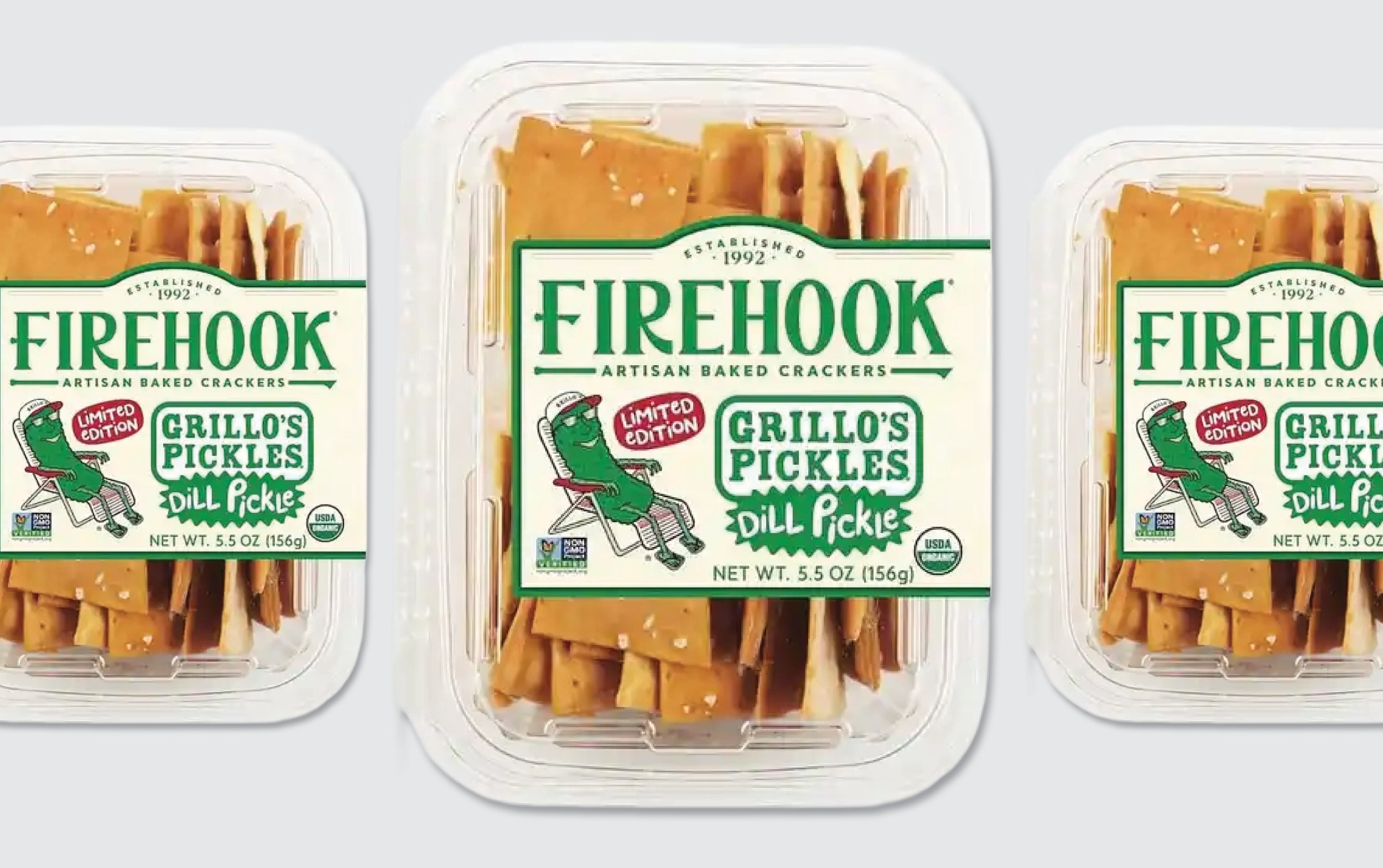 Three clear plastic containers of Firehook Artisan Baked Crackers in Grillo’s Pickles Dill Pickle flavor, with green and white labels featuring a pickle illustration and the text “Limited Edition.”.