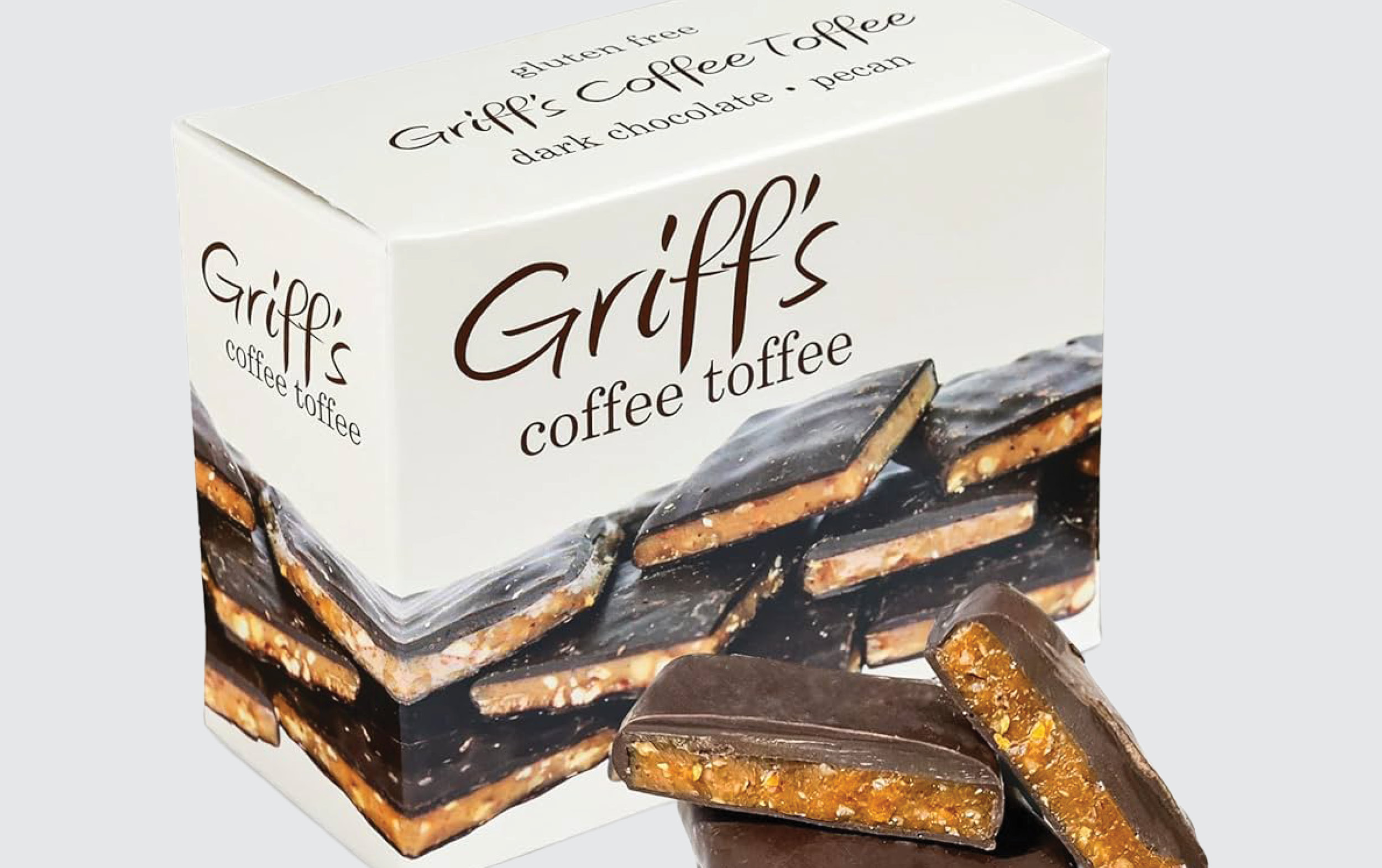A box of Griffs Coffee Toffee, labeled gluten free, dark chocolate, and pecan, with images of chocolate-covered toffee pieces on the packaging and two pieces of toffee in front.